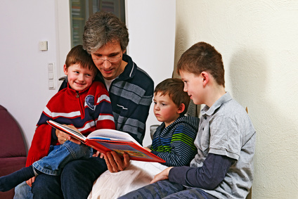 father reading a childrens book to his sons 01